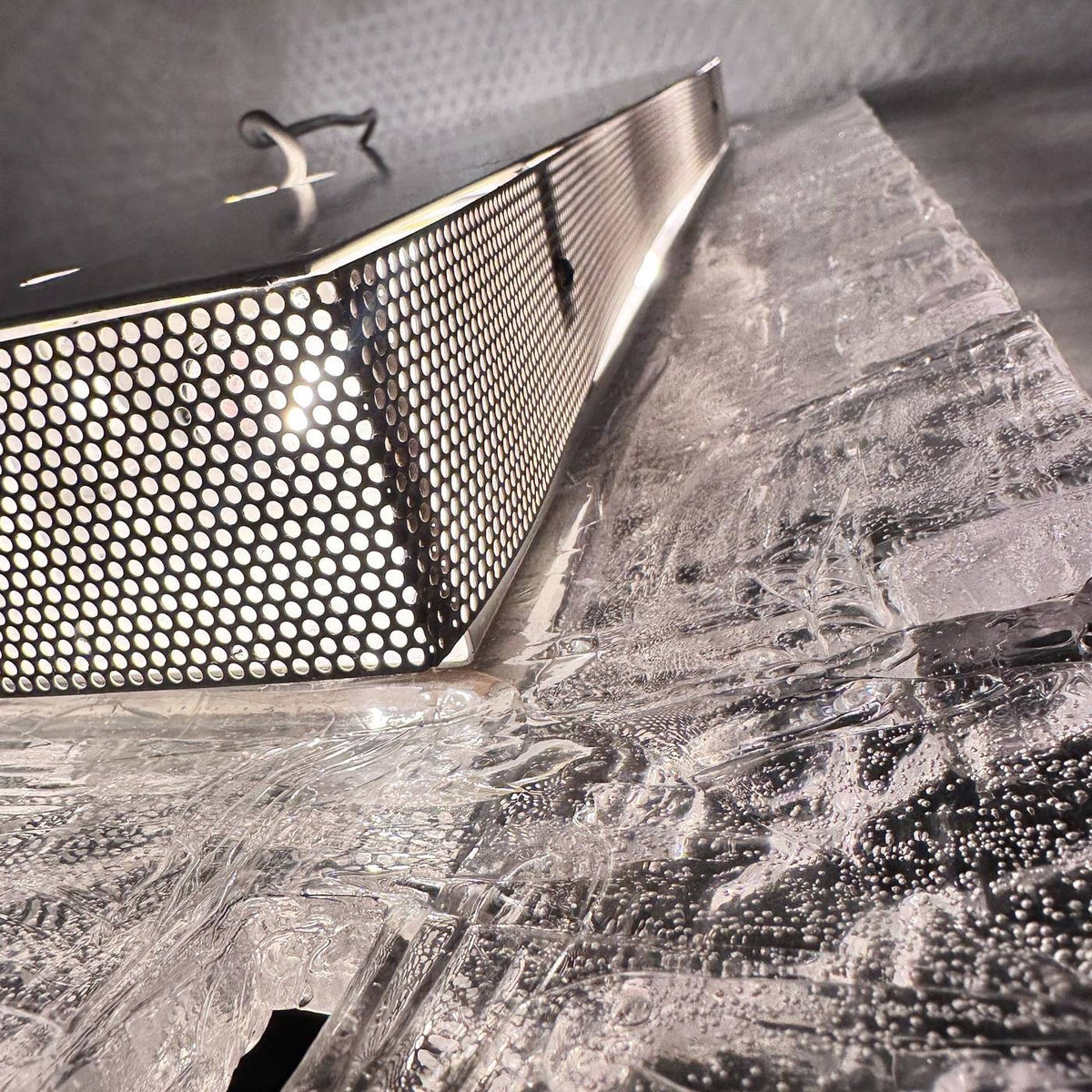 Lochblech-Blende des Gehäuses im Detail, Licht tritt durch die Perforation auf den Acrylrahmen