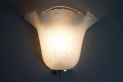 Eingeschaltete Murano-Glas-Wandleuchte mit warmem Licht hinter dem weißen Glasschirm