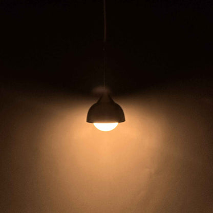 Weit entfernte Ansicht der eingeschalteten Tropfen-Pendelleuchte mit warmem Lichtkegel