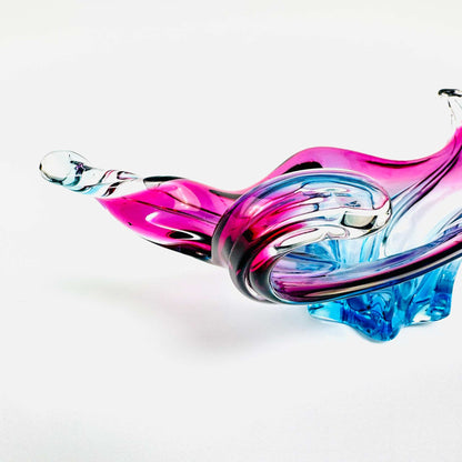 Nahaufnahme eines geschwungenen Randes der transparenten Murano-Schale mit pinken und blauen Farbverläufen