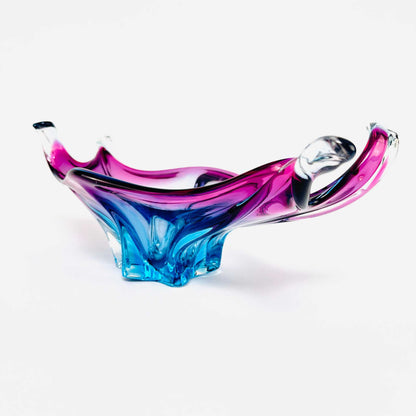 Ansicht der Glasschale von der rechten Seite mit transparenten pinken Bögen und blauem Standfuß