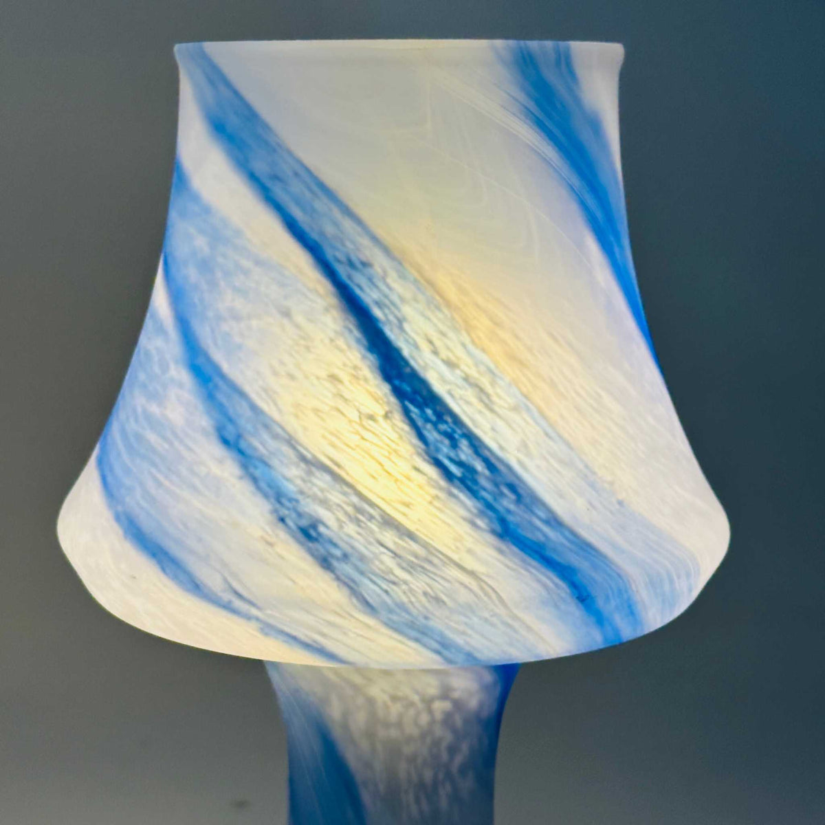 Eingeschalteter Glasschirm der zweiten Leuchte, kräftiger blau-weißer Swirl im Gegenlicht