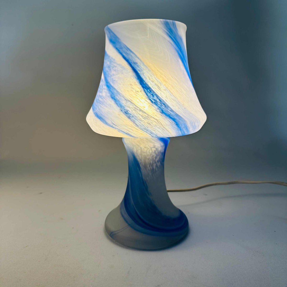 Einzelne Pilz-Tischleuchte eingeschaltet, blauer Swirl bis in den Fuß, Gesamtansicht