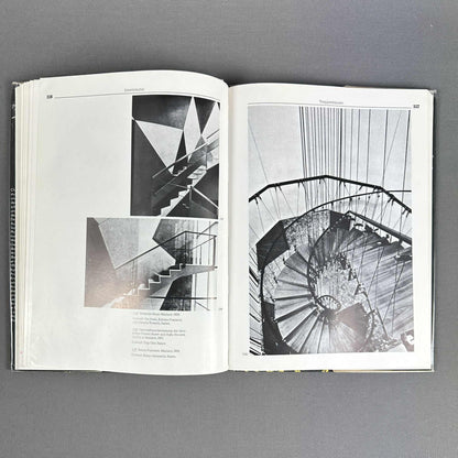 Offene Buchseiten mit Fotos einer skulpturalen Treppe und eines spiralförmigen Treppenhauses