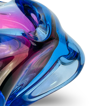 Detail des eingeschlagenen Randes aus hellblauem Glas über violettem Kern