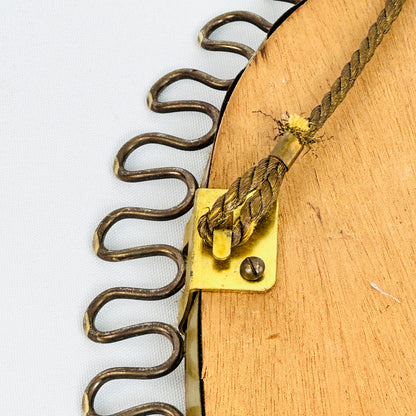 Detail der rückseitigen Kordelbefestigung auf der Holzplatte des Messing-Wandspiegels