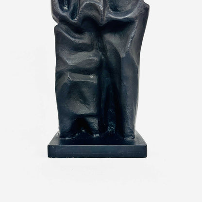 Detail der modellierten Beine und des rechteckigen Sockels der abstrakten Eisenskulptur Familie