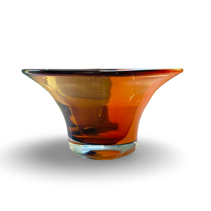 Schrägansicht der bernsteinfarbenen Glasschale aus den 1980/90ern mit klarem Fuß und orangem Rand