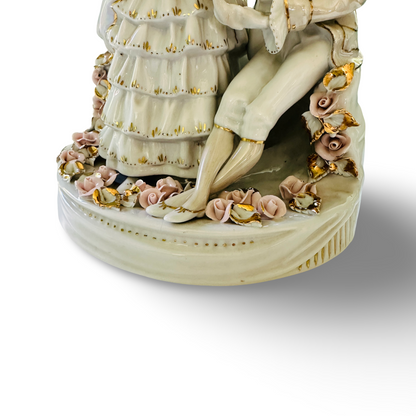 Detail des runden Porzellansockels mit Rosenblüten und den Füßen der Rokoko-Figuren