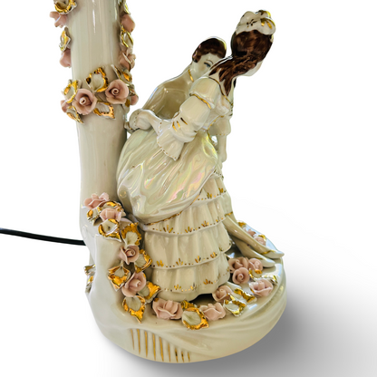 Seitliche Detailansicht der sitzenden Porzellanfigur und des blütenverzierten Leuchtenfußes
