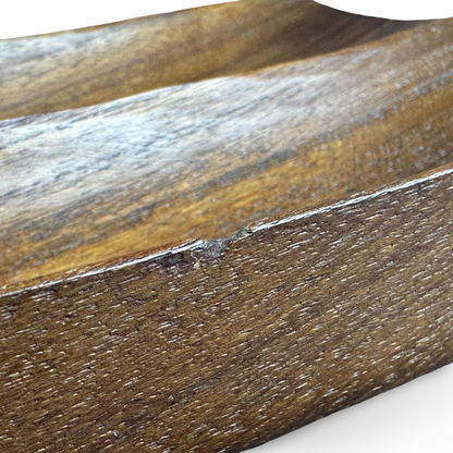Detailaufnahme der gealterten Teakoberfläche an der Kante der länglichen Holzschale