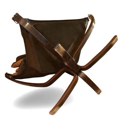 Rückansicht des Falcon Chair mit dunkler Lederbespannung und kreuzförmigem Fußgestell