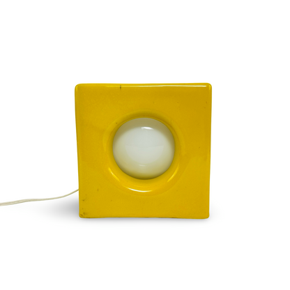 Frontansicht der signalgelben Keramiklampe mit runder Öffnung und innenliegender weißer Kugelbirne