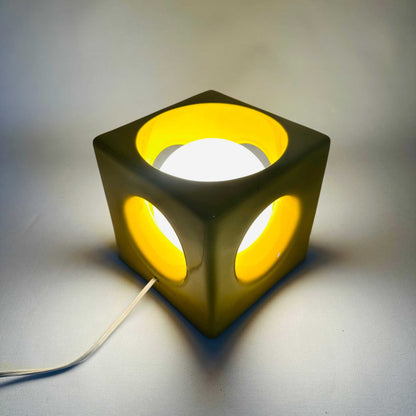 Eingeschaltete gelbe Würfel-Tischlampe aus Keramik mit leuchtenden runden Öffnungen im Space-Age-Stil