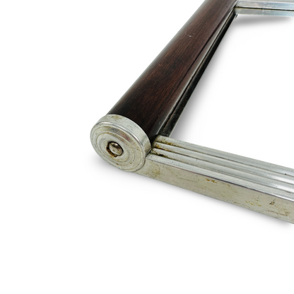 Detail eines Art-Deco-Tabletts mit geriffeltem Metallrahmen, Holzgriff und spiraliger Endkappe