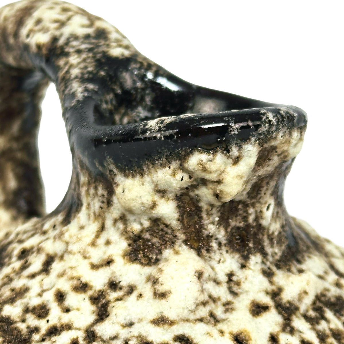 Détail de l’embouchure émaillée noir et de la glaçure cratère mouchetée de brun sur le col