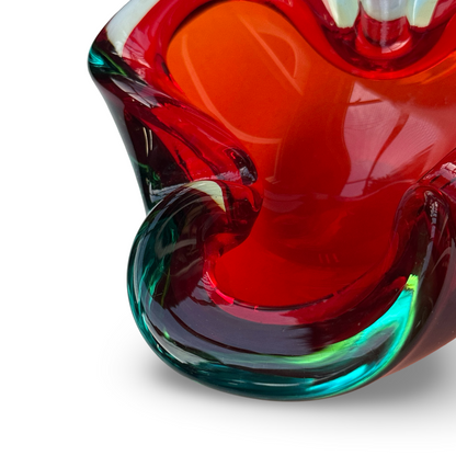 Nahaufnahme der roten Innenmulde und des geschwungenen türkisgrünen Randes der Glasschale