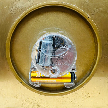 Nahaufnahme des geöffneten Batteriefachs und Uhrwerks auf der Rückseite der Tischuhr