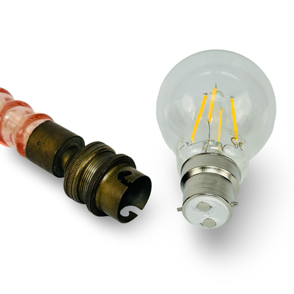 Detail der Bajonettfassung neben einer klaren LED-Glühbirne für die französische Tischlampe