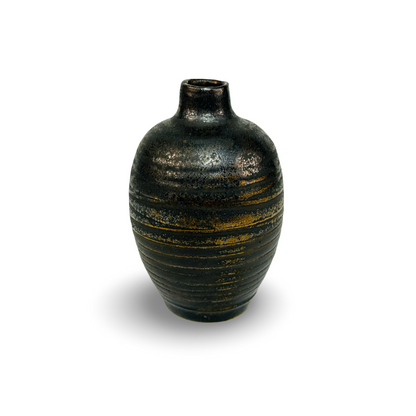 Nahansicht des gerippten Korpus der Miniatur-Vase in Schwarz mit unregelmäßiger Bronze-Glasur