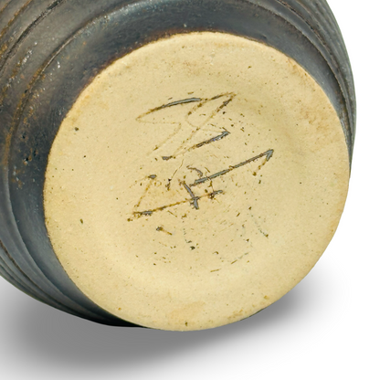 Schrägansicht der geriffelten Miniatur-Vase aus schwarzer Studiokeramik mit bronzenen Glanzspuren