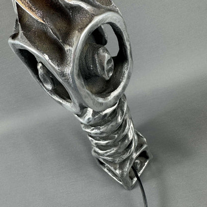 Nahaufnahme des schweren Metallfußes mit runden Durchbrüchen und gewundener Struktur