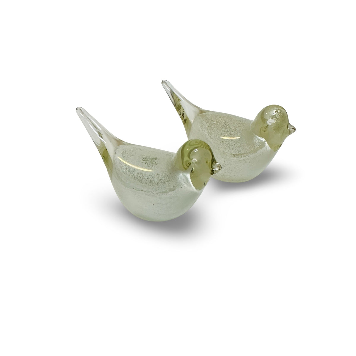 Two glass birds with clear heads and raised tails, oblique view from behind