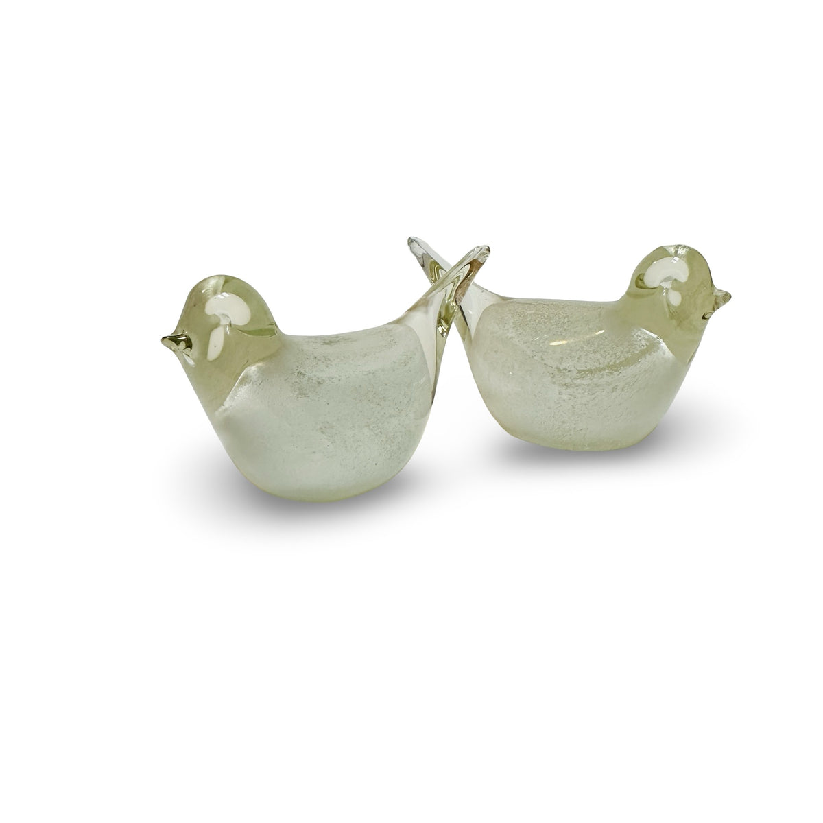 Glass birds back to back with crossed tails, side view with white glass eyes