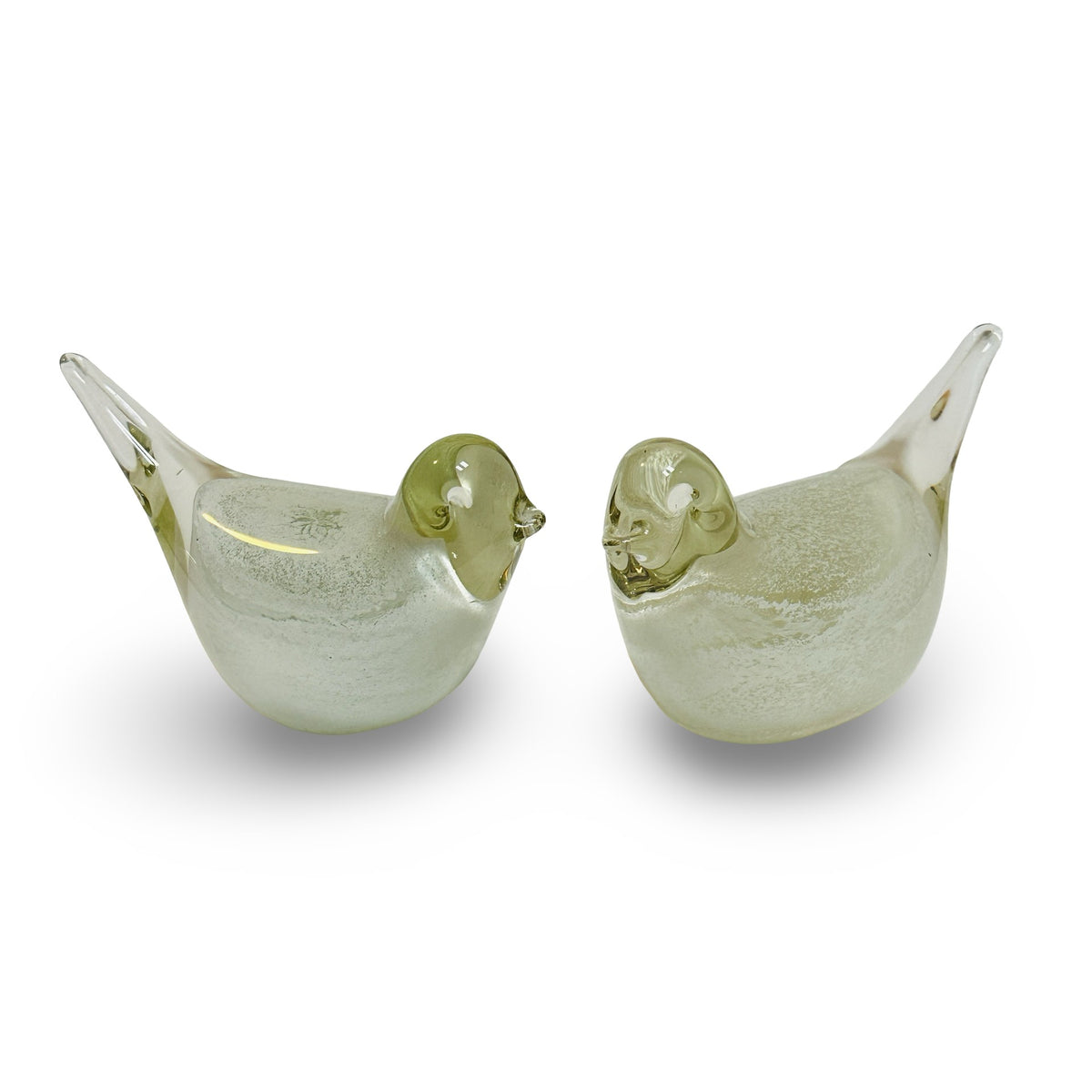 Pair of vintage clear glass birds with white powder core, facing each other, isolated