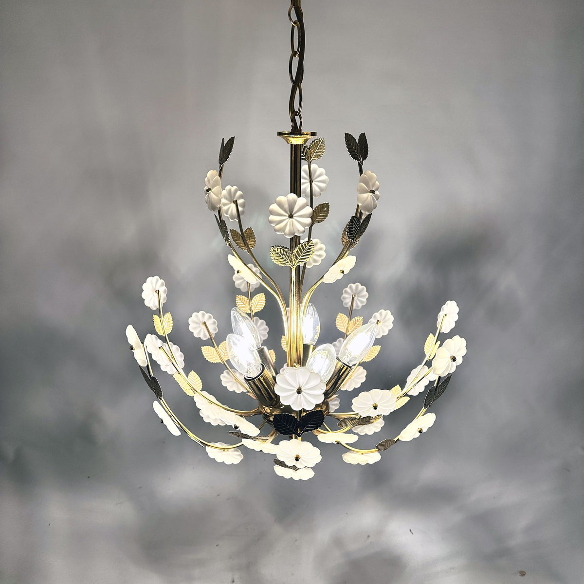 Lustre Ideal Lux allumé, fleurs en verre satiné à la lueur chaude sur fond gris