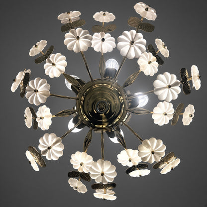 Lustre Ideal Lux allumé vu de dessous, coupelle en laiton avec couronne de fleurs en verre satiné et feuilles en laiton sur fond gris