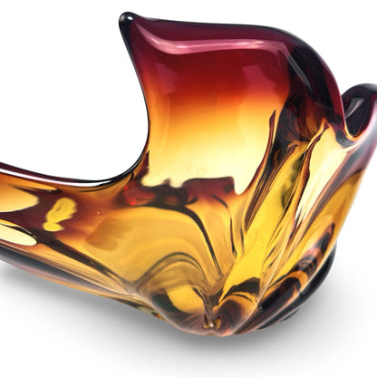 Close-up of a raised scroll and the thick-walled amber glass of the Murano bowl