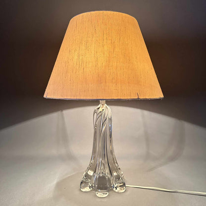 Eingeschaltete Murano-Tischleuchte mit warm leuchtendem Schirm und transparentem Glasfuß