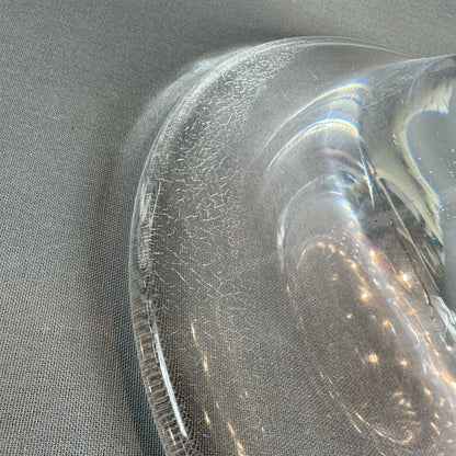 Detail des transparenten Acrylfußes mit feinen Kratzspuren an der runden Standplatte