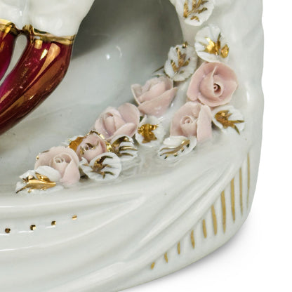 Aufgelegte rosa Porzellanrosen mit vergoldeten Blättern am drapierten Sockel, Detail