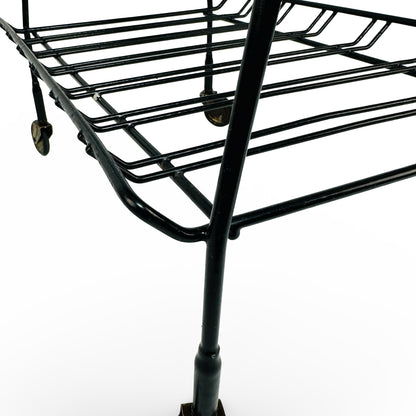 Detail of leg, sleeve and lower wire rack with brass castor in the background
