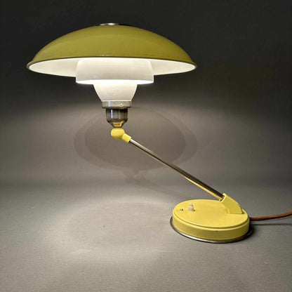 Gesamtansicht der eingeschalteten gelben Tischleuchte mit Chromarm, Pilzschirm und Textilkabel, 1960er